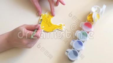 女孩的手`粉刷石膏图形的颜色特写。 我们用水彩和<strong>颜料画</strong>画。